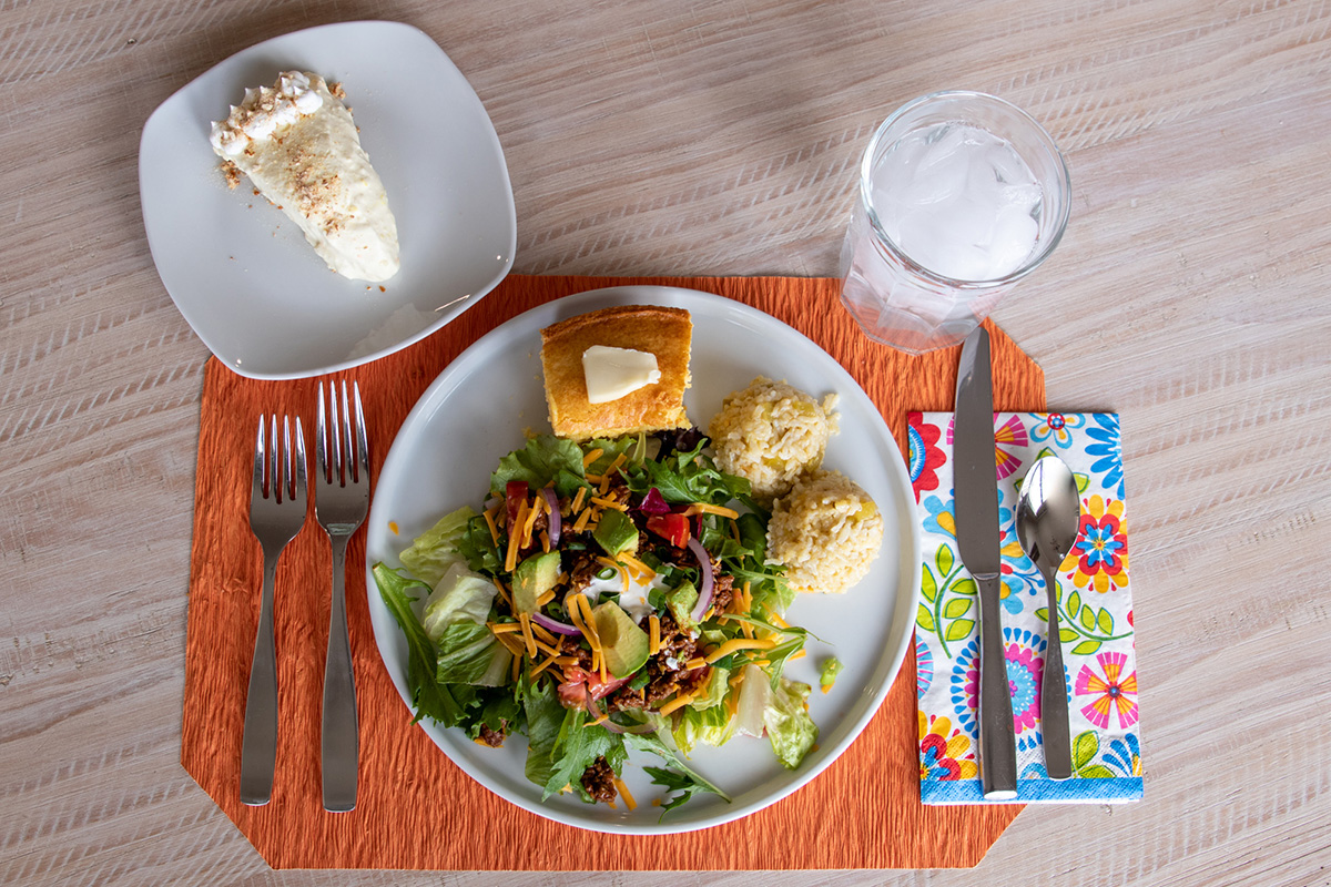A plate on a table with beef in a salad on the plate